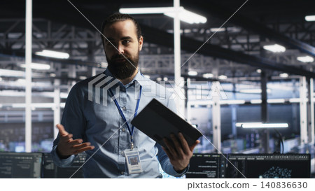 Data center lead programmer presents AI server technology during a filmed tour of high-tech infrastructure. Data center lead programmer presents AI server technology during a filmed tour of high-tech infrastructure. 140836630