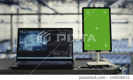 Technology specialist uses a green screen tablet in a server room for AI workflow and screen replacement. Technology specialist uses a green screen tablet in a server room for AI workflow and screen replacement. 140836631