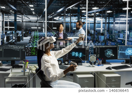 Administrator wears a headset in a server hub, using artificial intelligence troubleshooting to assist users. Administrator wears a headset in a server hub, using artificial intelligence troubleshooting to assist users. 140836645