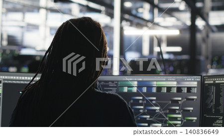 Data center engineer reviews artificial intelligence systems and machine learning processes inside a data center. Data center engineer reviews artificial intelligence systems and machine learning processes inside a data center. 140836649