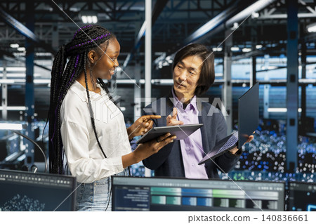 Engineer tunes AI model settings on a computer workstation in a server room to improve systems. 140836661