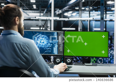Software developer uses a green screen computer to manage AI systems, machine learning workflows and server performance. Software developer uses a green screen computer to manage AI systems, machine learning workflows and server performance. 140836686