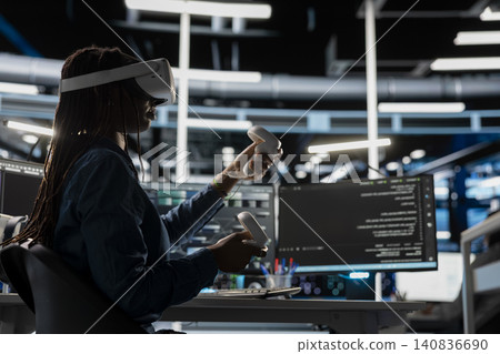Data center engineer uses a VR headset in a data center to manage AI systems, train neural networks, and configure hardware. Data center engineer uses a VR headset in a data center to manage AI systems, train neural networks, and configure hardware. 140836690