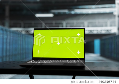 Green screen laptop in a data center supports automation monitoring, screen replacement, and editable monitoring workflows. 140836714