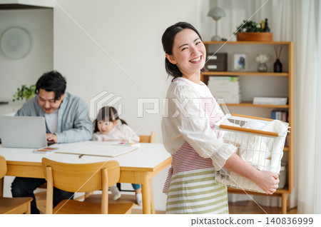 一位年輕家庭主婦在家洗衣服的肖像。 一位年輕家庭主婦在家洗衣服的肖像。 140836999