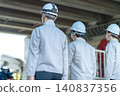 三名身穿工作服的男性工作人員的背影，他們正前往建築工地。 140837356