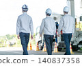 三名身穿工作服的男性工作人員的背影，他們正前往建築工地。 140837358