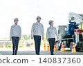低角度正面拍攝的三名工人走在一輛特種車輛前面的畫面。 140837360