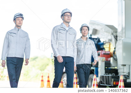 三名身穿工作服的男性工作人員在建築工地上行走的全身鏡頭。 三名身穿工作服的男性工作人員在建築工地上行走的全身鏡頭。 140837362