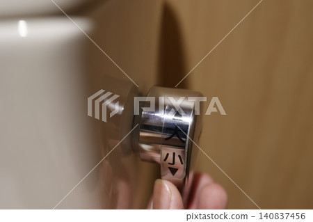 Toilet flush lever. Selection of large or small water flow. Close-up shot. Toilet flush lever. Selection of large or small water flow. Close-up shot. 140837456