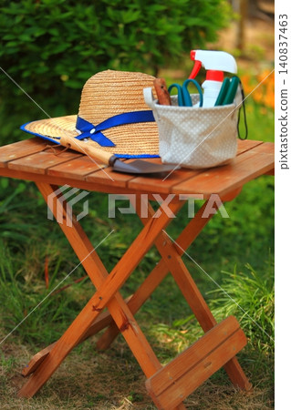 Image of a straw hat and gardening supplies for heatstroke and UV protection. Image of a straw hat and gardening supplies for heatstroke and UV protection. 140837463