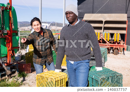 African-american man worker carrying crates, employer pointing finger African-american man worker carrying crates, employer pointing finger 140837737