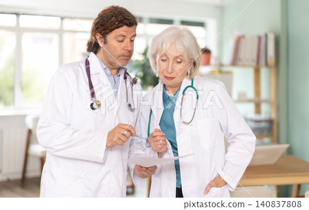 Elderly woman and adult male doctors discussing medical tests 140837808