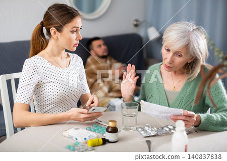 Young wife and an elderly mother discuss what medicines are needed for sick husband Young wife and an elderly mother discuss what medicines are needed for sick husband 140837838