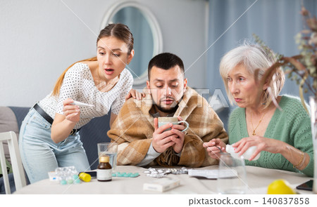 Young sick man choosing drugs with family Young sick man choosing drugs with family 140837858