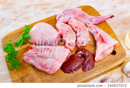 Sliced raw rabbit meat with spices on cutting board on wooden table Sliced raw rabbit meat with spices on cutting board on wooden table 140837872