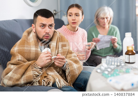Sick man sitting with wife and mother Sick man sitting with wife and mother 140837884
