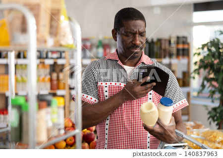 African male client scans QR code on mayonnaise package 140837963