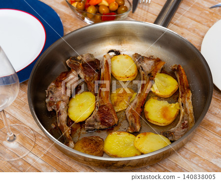 Seared and roasted lamb ribs served with baked potato on table, top view. Seared and roasted lamb ribs served with baked potato on table, top view. 140838005
