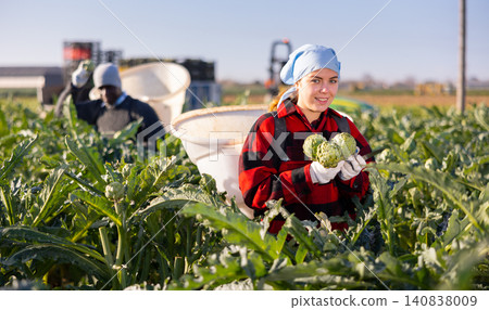 Portrait young woman gardener on artichoke plantation 140838009