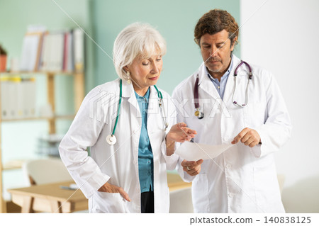 Elderly woman and adult male doctors discussing medical tests Elderly woman and adult male doctors discussing medical tests 140838125