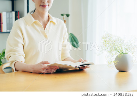 一位年輕女子在家讀書時的雙手 一位年輕女子在家讀書時的雙手 140838182