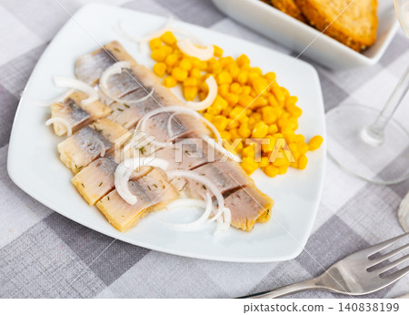 Slices of spicy marinated herring fillet with corn and onion Slices of spicy marinated herring fillet with corn and onion 140838199