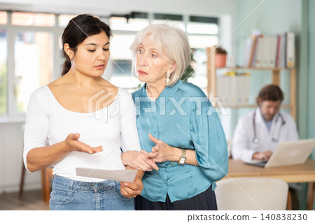 Worried elderly woman discussing medical tests with daughter Worried elderly woman discussing medical tests with daughter 140838230