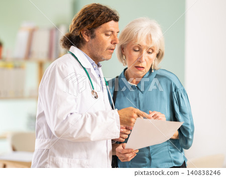 Adult male doctor discussing test results with female patient Adult male doctor discussing test results with female patient 140838246