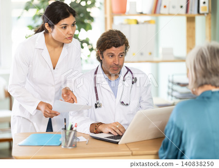 Male and female doctors explaining diagnostic results to elderly patient Male and female doctors explaining diagnostic results to elderly patient 140838250