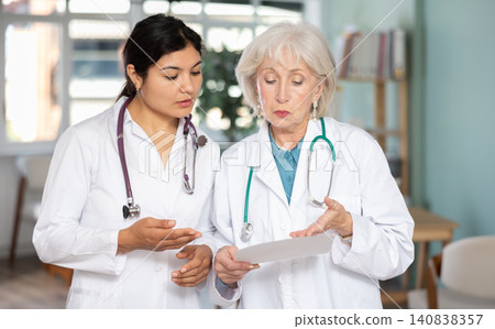 Two female doctors review or read medical documents 140838357