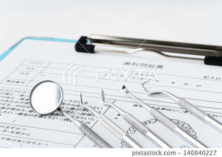 Close-up of dental questionnaires and medical instruments (scalers) Close-up of dental questionnaires and medical instruments (scalers) 140840227