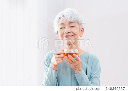 一位老婦人正在喝熱飲 140840337