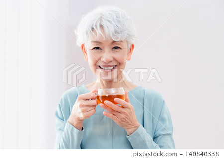 一位老婦人正在喝熱飲 140840338