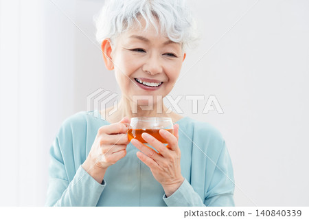 一位老婦人正在喝熱飲 140840339