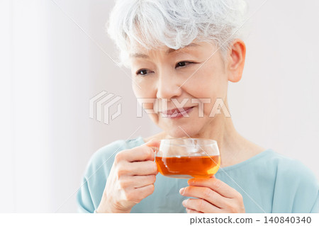 一位老婦人正在喝熱飲 140840340