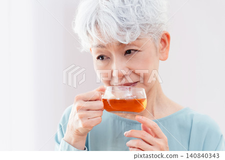 一位老婦人正在喝熱飲 140840343