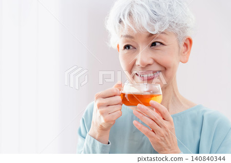 一位老婦人正在喝熱飲 140840344