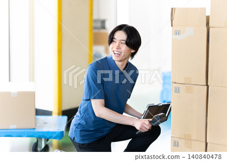 Staff using terminals in the warehouse 140840478