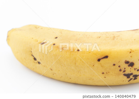 A close-up of a slightly browned banana against a white background. A close-up of a slightly browned banana against a white background. 140840479