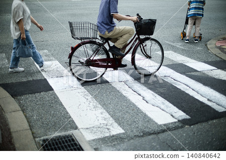 一輛腳踏車、一位推著嬰兒車的老婦人和行人。 一輛腳踏車、一位推著嬰兒車的老婦人和行人。 140840642