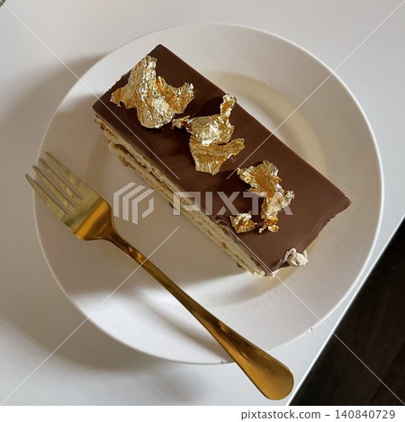Elegant layered opera cake with rich coffee syrup, silky buttercream, and glossy chocolate ganache. A refined, aromatic dessert with smooth textures and deep, luxurious flavor. Elegant layered opera cake with rich coffee syrup, silky buttercream, and glossy chocolate ganache. A refined, aromatic dessert with smooth textures and deep, luxurious flavor. 140840729