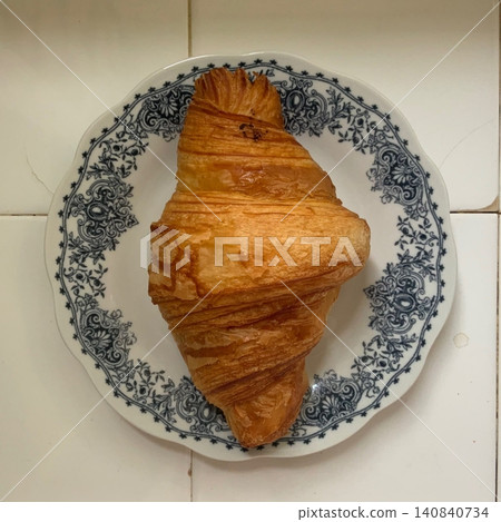 A croissant is a classic French pastry known for its buttery, flaky layers and golden crust. Often enjoyed plain or filled with chocolate, almond, or ham and cheese, it’s a perfect for breakfast 140840734