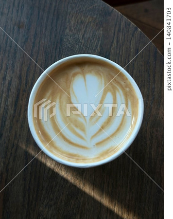 A beautifully crafted latte, featuring creamy foam art on top of rich espresso. Perfect for coffee-related projects, this image captures the warmth and inviting nature of a classic cafe experience. A beautifully crafted latte, featuring creamy foam art on top of rich espresso. Perfect for coffee-related projects, this image captures the warmth and inviting nature of a classic cafe experience. 140841703