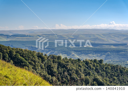 Panoramic view of the green valley and the snowy peak of Mount Elbrus on the horizon against the blue sky on a sunny clear morning in Kislovodsk Stavropol territory, Russia Panoramic view of the green valley and the snowy peak of Mount Elbrus on the horizon against the blue sky on a sunny clear morning in Kislovodsk Stavropol territory, Russia 140841910