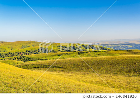 Layers of green mountains and hills in the haze during sunset. Panoramic View of Green hills and Meadow. 140841926