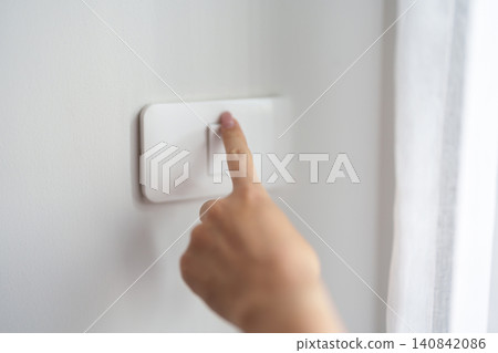 Female finger pushing for turn on light switch on white wall at home room. Woman hand turn off lighting Switch. Energy Saving, energy power control, electrical, eco environment, and lifestyle concept Female finger pushing for turn on light switch on white wall at home room. Woman hand turn off lighting Switch. Energy Saving, energy power control, electrical, eco environment, and lifestyle concept 140842086