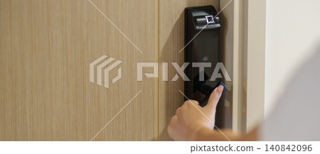 Hand using smart digital door lock while open or close the door at home or apartment. NFC Technology, Fingerprint scan, keycard, PIN number, smartphone, electrical and contactless lifestyle concepts Hand using smart digital door lock while open or close the door at home or apartment. NFC Technology, Fingerprint scan, keycard, PIN number, smartphone, electrical and contactless lifestyle concepts 140842096