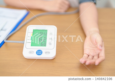 woman checking Blood pressure by Blood pressure monitor with Cuff. Systolic, SYS, Diastolic, DIA, Pulse, Hypertension, Hypotension, Heart rate, Cardiovascular Disease and May World hypertension day woman checking Blood pressure by Blood pressure monitor with Cuff. Systolic, SYS, Diastolic, DIA, Pulse, Hypertension, Hypotension, Heart rate, Cardiovascular Disease and May World hypertension day 140842106