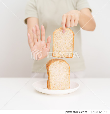 Unhappy woman showing Rejecting gesture and refusing to eat bread. concept of gluten intolerance, gluten sensitivity, carb loading concerns, or a disliking for unhealthy dietary habits Unhappy woman showing Rejecting gesture and refusing to eat bread. concept of gluten intolerance, gluten sensitivity, carb loading concerns, or a disliking for unhealthy dietary habits 140842135